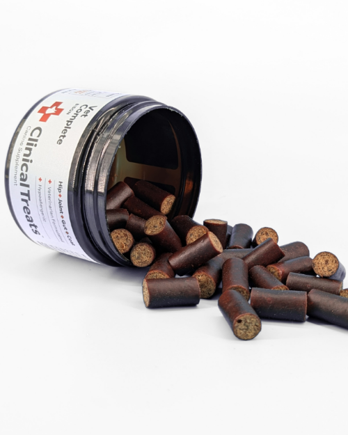 Open container of Clinical Treats with treats spilling out on a white background
